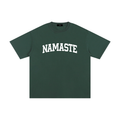 Unisex forest green 100% cotton tee featuring "NAMASTE" arched in white varsity-style lettering.